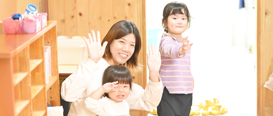 園児と保育士こちらに向かって手を振っている写真